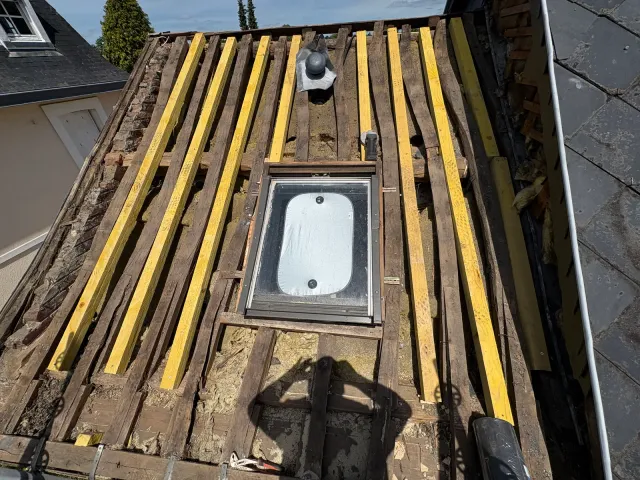 Charpente reprise et ardoise reposée autour d'un velux par un couvreur dans l'agglomération du Havre (76)